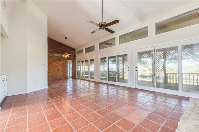 interior space featuring tile patterned flooring, high vaulted ceiling, ceiling fan, and wood walls