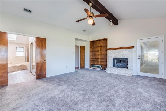 unfurnished living room featuring vaulted ceiling with beams, ceiling fan, light colored carpet, and a fireplace