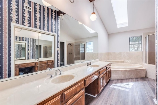 bathroom with hardwood / wood-style floors, vanity, separate shower and tub, and vaulted ceiling with skylight