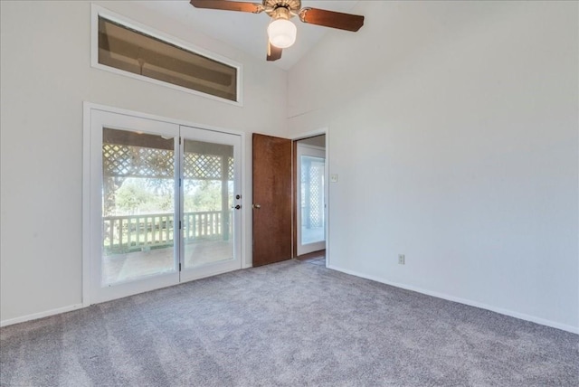 carpeted spare room featuring ceiling fan and high vaulted ceiling