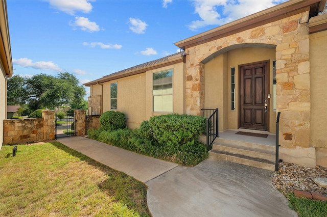 view of exterior entry with a yard