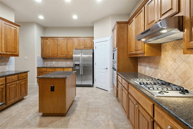 kitchen with a kitchen island, decorative backsplash, dark stone countertops, and stainless steel appliances