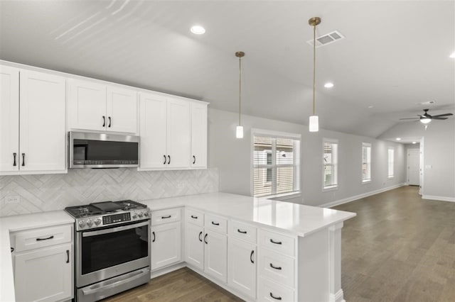 kitchen with kitchen peninsula, stainless steel appliances, white cabinets, hanging light fixtures, and lofted ceiling