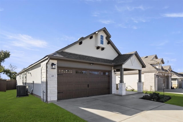 view of front of home featuring central AC, a garage, and a front lawn