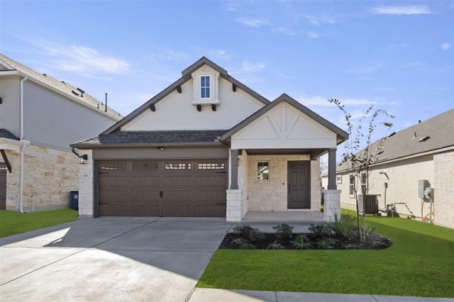 view of front facade featuring a garage, covered porch, a front yard, and cooling unit