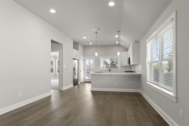 kitchen with dark wood-type flooring, stainless steel refrigerator with ice dispenser, kitchen peninsula, pendant lighting, and white cabinets