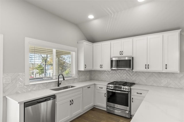 kitchen with white cabinetry, lofted ceiling, sink, and appliances with stainless steel finishes