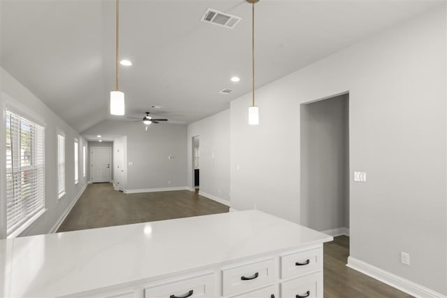 kitchen with ceiling fan, dark hardwood / wood-style flooring, vaulted ceiling, decorative light fixtures, and white cabinets