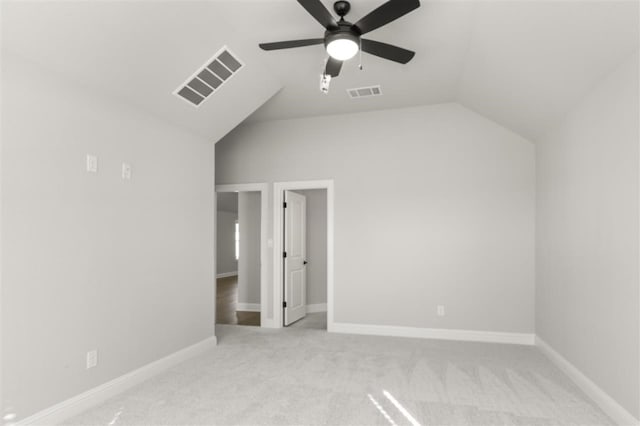 unfurnished bedroom with ceiling fan, light carpet, and vaulted ceiling