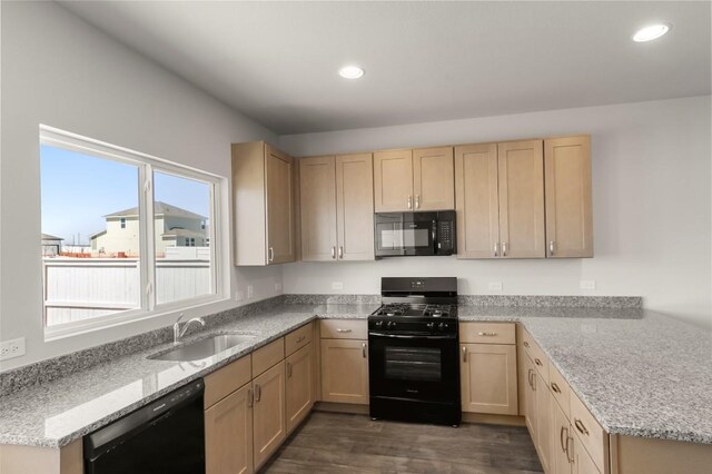 224 Barley Ln, Elgin, TX 78621 - kitchen with a sink, a peninsula, black appliances, and light brown cabinetry