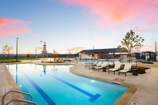 224 Barley Ln, Elgin, TX 78621 - pool at dusk with fence, a community pool, and a patio area