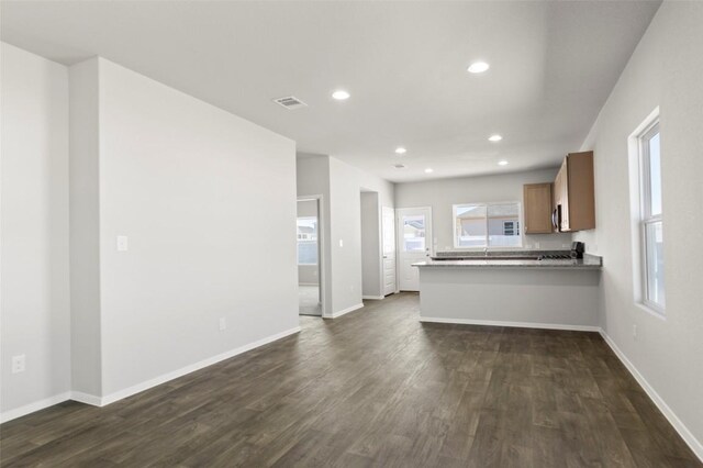224 Barley Ln, Elgin, TX 78621 - unfurnished living room featuring baseboards, visible vents, recessed lighting, and dark wood-style flooring