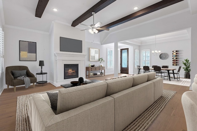 living room featuring beamed ceiling, ceiling fan with notable chandelier, light hardwood / wood-style floors, and ornamental molding