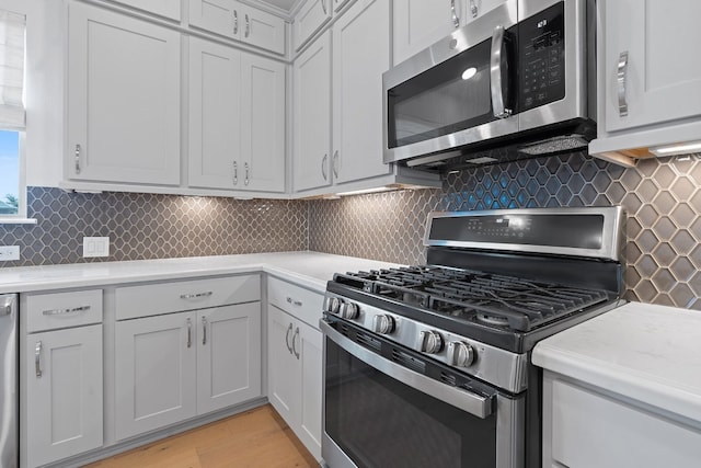 kitchen featuring stainless steel appliances, light hardwood / wood-style flooring, and tasteful backsplash