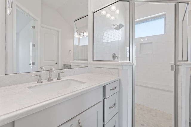 bathroom with vanity, lofted ceiling, and walk in shower