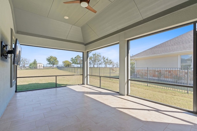 unfurnished sunroom with ceiling fan and vaulted ceiling