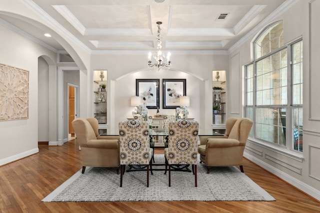 sitting room featuring hardwood / wood-style floors, crown molding, coffered ceiling, and a chandelier