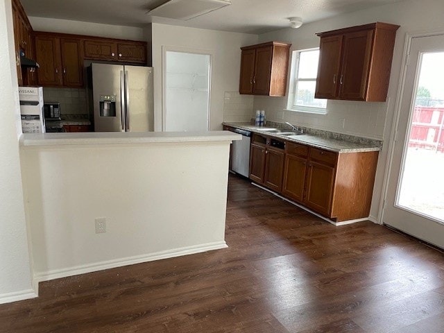 kitchen featuring a wealth of natural light, dark wood-type flooring, appliances with stainless steel finishes, and tasteful backsplash