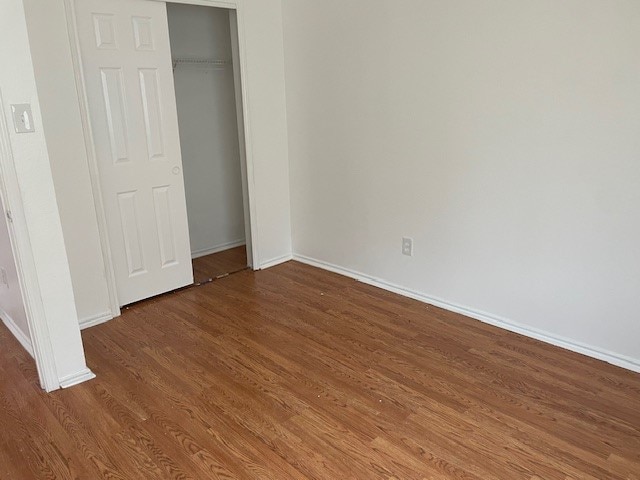 unfurnished bedroom with hardwood / wood-style floors and a closet