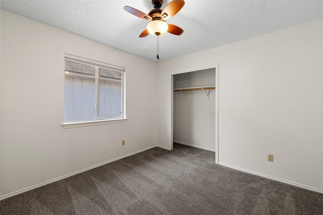 unfurnished bedroom featuring dark colored carpet, ceiling fan, a textured ceiling, and a closet