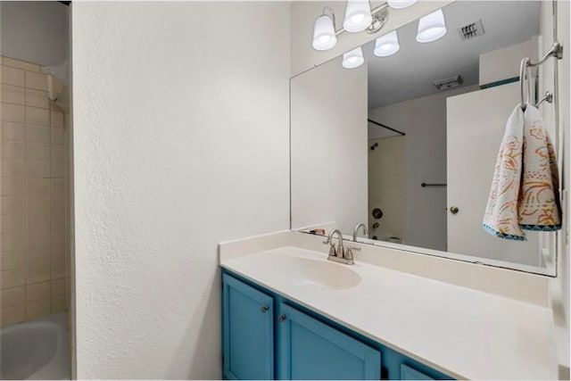 bathroom featuring vanity and tiled shower / bath