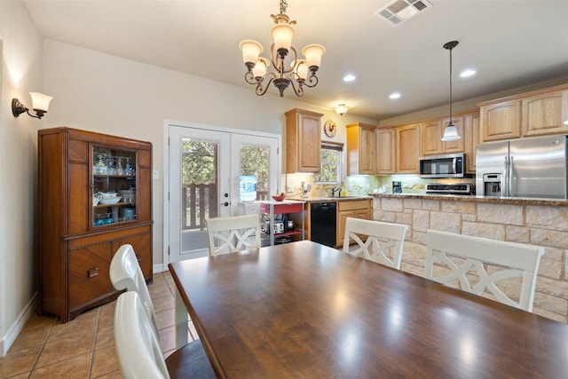 dining room with a chandelier, french doors, and sink