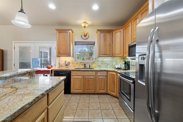 kitchen featuring light stone countertops, backsplash, stainless steel appliances, sink, and decorative light fixtures