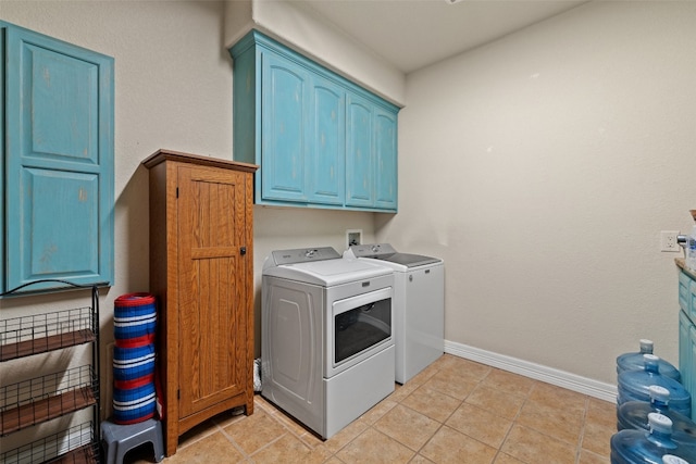 laundry area featuring cabinets, light tile patterned floors, and washer and dryer