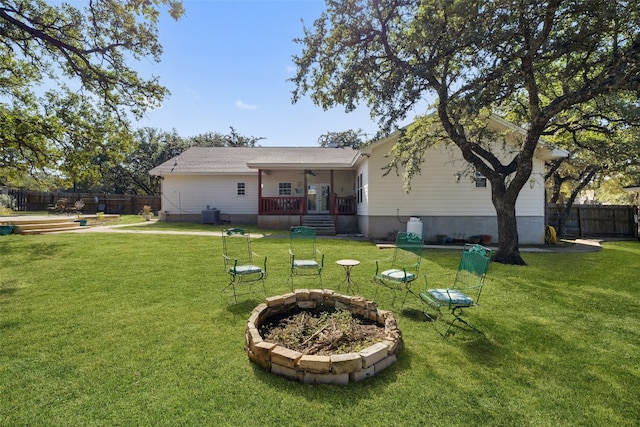 back of property featuring a lawn, ceiling fan, cooling unit, and a porch