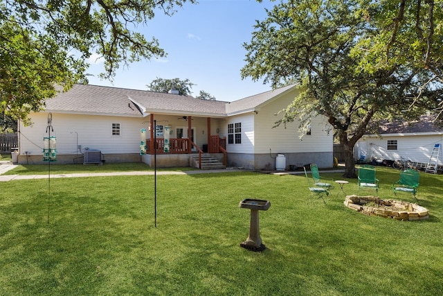 rear view of property featuring a lawn and cooling unit