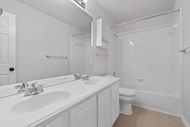 full bathroom featuring vanity, tiled shower / bath, tile patterned floors, and toilet