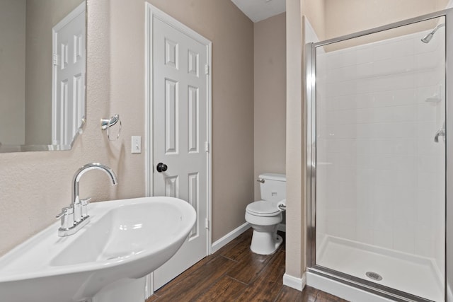 bathroom featuring sink, wood-type flooring, toilet, and walk in shower