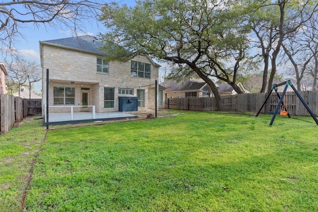 back of house featuring a yard, a playground, and a patio area