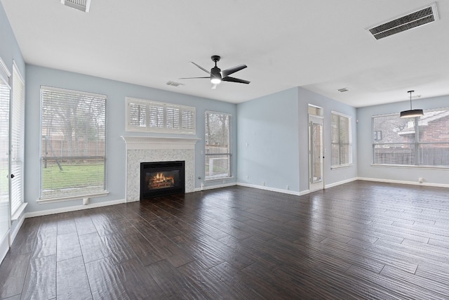 unfurnished living room featuring ceiling fan and dark hardwood / wood-style flooring