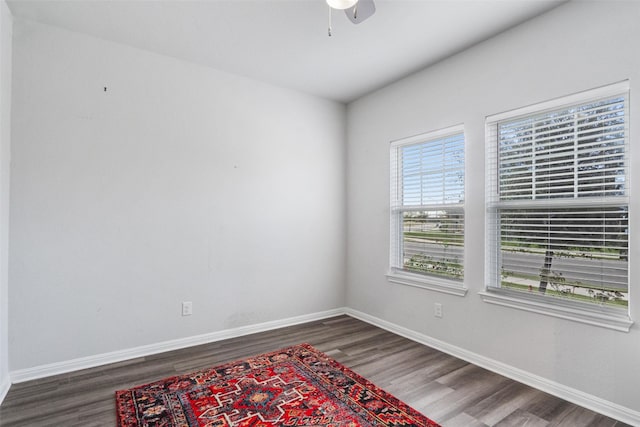 empty room with ceiling fan and dark hardwood / wood-style flooring