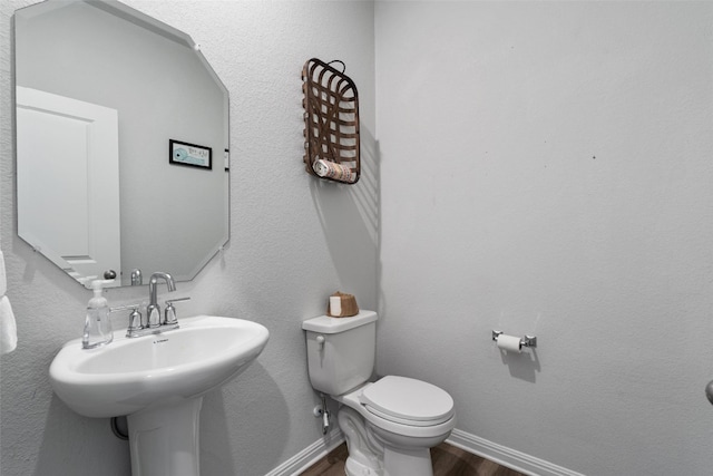 bathroom with sink, hardwood / wood-style floors, and toilet