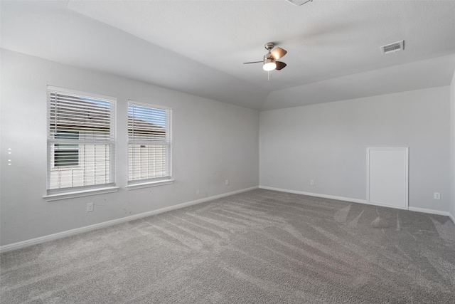 carpeted spare room with ceiling fan and vaulted ceiling