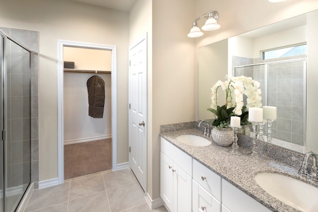 bathroom with tile patterned flooring, vanity, and a shower with shower door