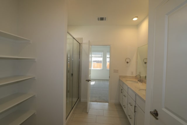 bathroom with vanity and a shower with door