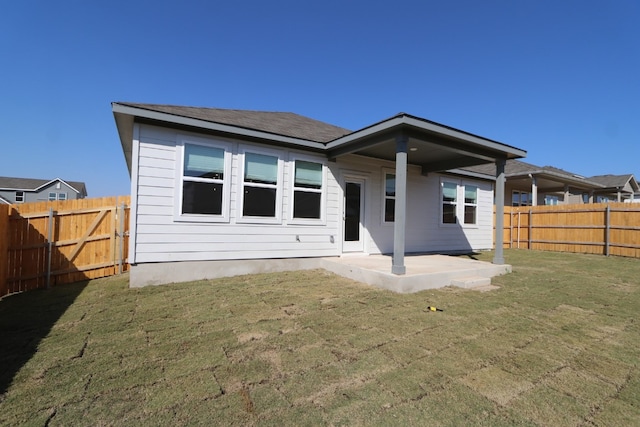 rear view of property with a yard and a patio