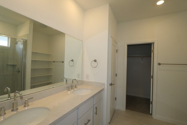 bathroom featuring a shower with door, vanity, and hardwood / wood-style floors