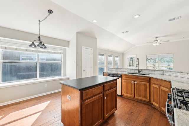 kitchen featuring hardwood / wood-style floors, stainless steel appliances, vaulted ceiling, and hanging light fixtures