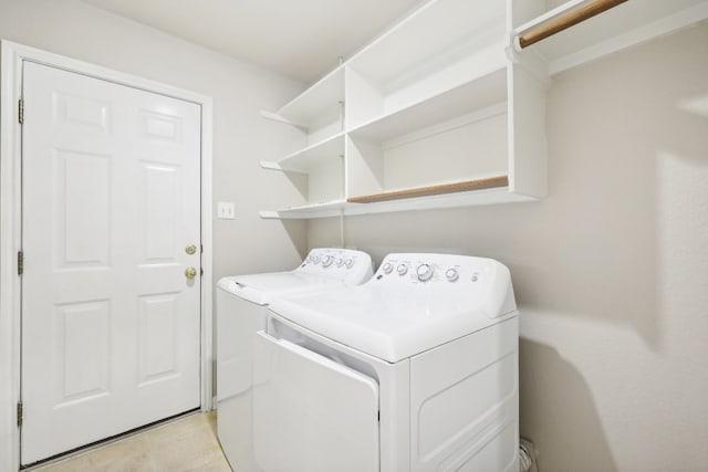 clothes washing area with washing machine and dryer and light tile patterned floors