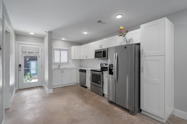 kitchen with stainless steel appliances, white cabinetry, tasteful backsplash, and sink