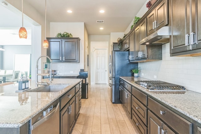 kitchen featuring dark brown cabinets, stainless steel appliances, hanging light fixtures, and sink