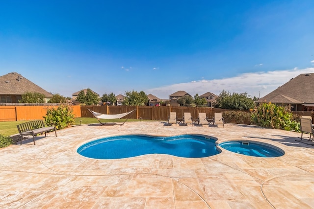 view of swimming pool with an in ground hot tub and a patio