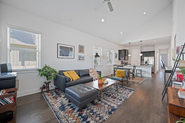 living room with dark hardwood / wood-style floors, high vaulted ceiling, ceiling fan, and a healthy amount of sunlight