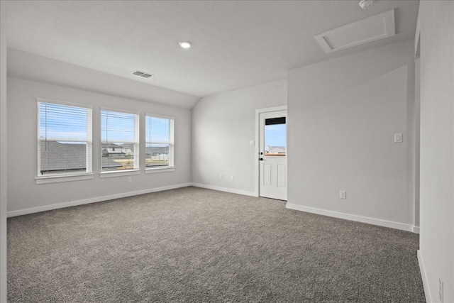 unfurnished room featuring dark carpet and vaulted ceiling