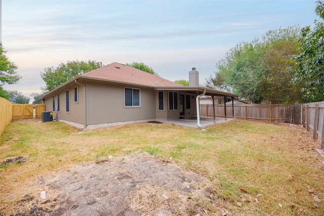 back of house featuring a patio, central AC, and a lawn