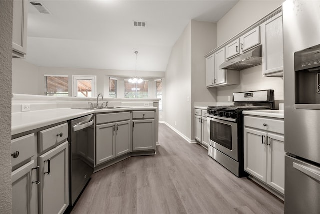 kitchen with appliances with stainless steel finishes, gray cabinetry, vaulted ceiling, light hardwood / wood-style flooring, and hanging light fixtures